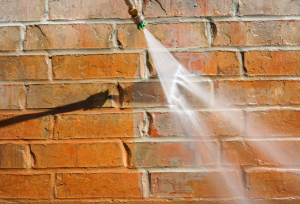 Pressure washing a brick wall